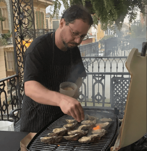 Brandon Blackwell cooks oysters over a grill
