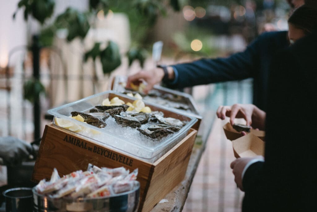 Guest serves themself from a box of oysters on ice