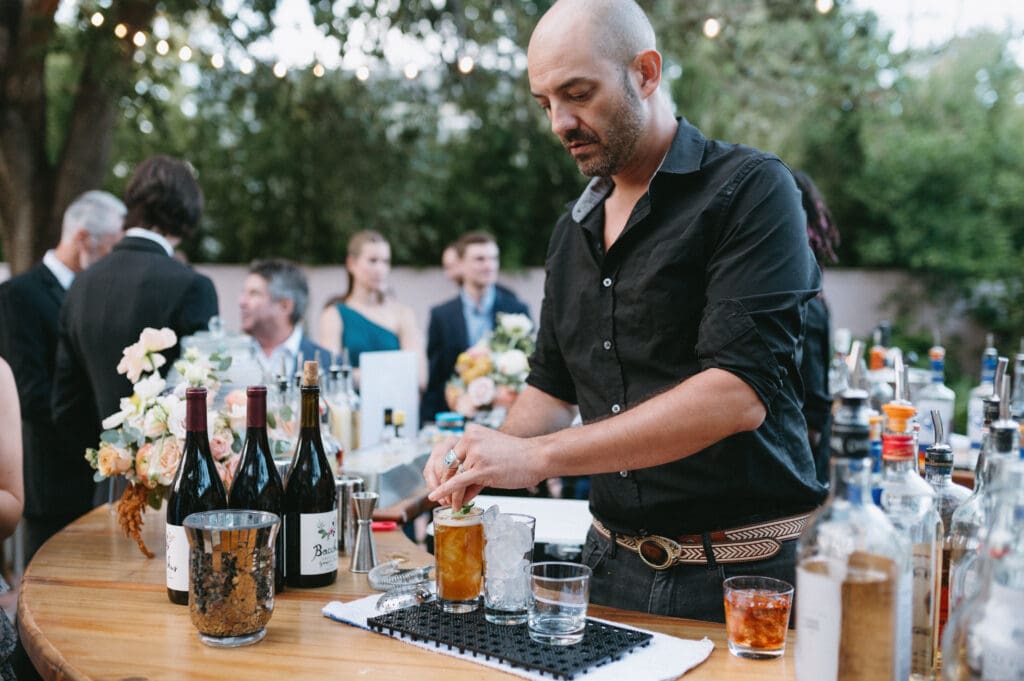 Bartender puts garnish on a drink at a wedding