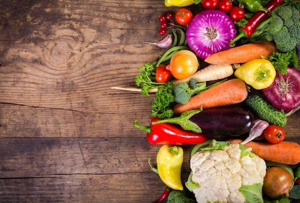 Plenty of colorful vegetables on wooden table with copy space