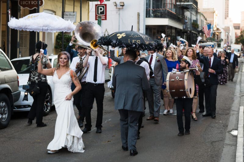A Nola second line dancing through the French quarter late in the day on Royal street.