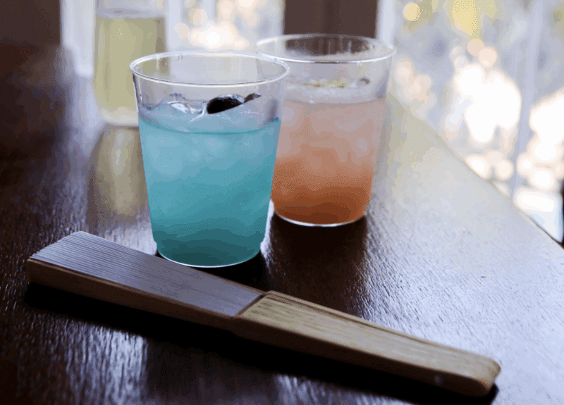 two drinks on a table, one blue and one red, showcasing the art of the wedding cocktail hour in new orleans