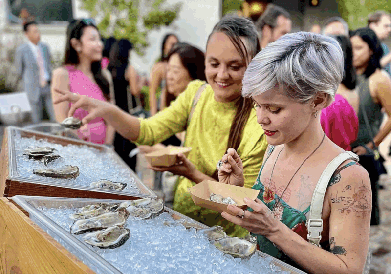 Table shows oysters on ice and guests practicing good oyster catering safety by keeping them cold